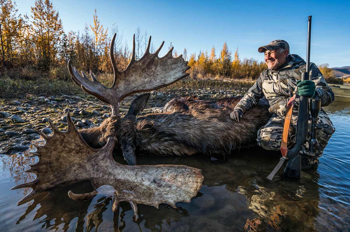 Caza de alces del Yukón con arco, padre e hijo tras el gigante de Canadá
