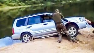 Unos cazadores intentan rescatar un coche situado al borde de un río y la lían