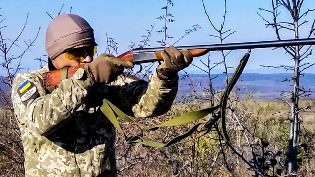 Un cazador ucraniano encarando una escopeta de caza.