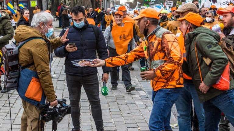 Un grupo de cazadores ofrece un plato de jamón a los reporteros de La Sexta en plena manifestación. © Israel Hernández