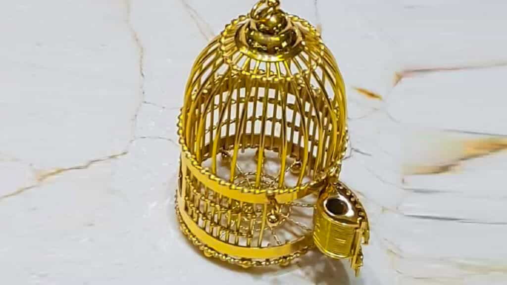 La jaula de la perdiz con reclamo de oro en miniatura.