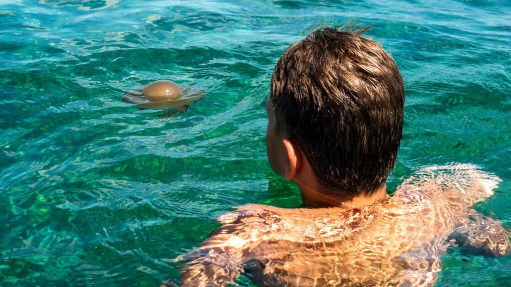 Un niño observa una medusa en el mar Mediterráneo. 