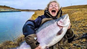 Una mujer pesca una gigantesca trucha de casi 14 kilos