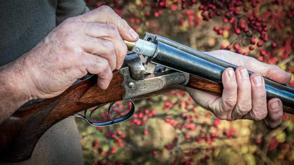 Un cazador carga una vieja escopeta paralela.