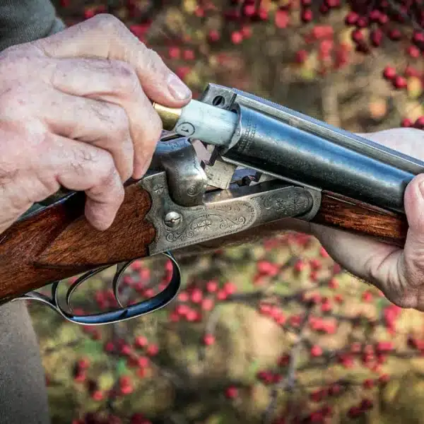 Un cazador carga una vieja escopeta paralela.