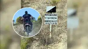 Un temerario motorista se burla de un cartel que prohíbe el paso a un coto de caza y lo invade con su Derbi FDS