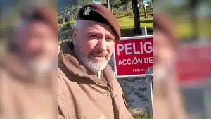 Un guarda de caza muestra el cartel al que los viandantes deben poner especial atención.