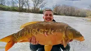 Un joven pesca una gran carpa de 14 kilos en Navarra.