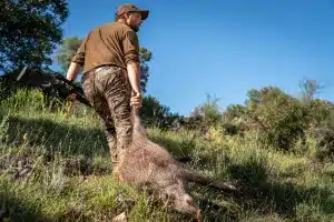 Un cazador con un jabalí.