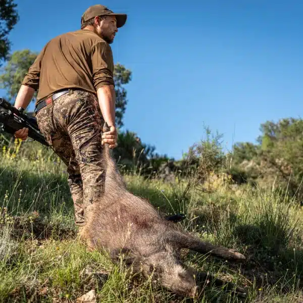 Un cazador con un jabalí.