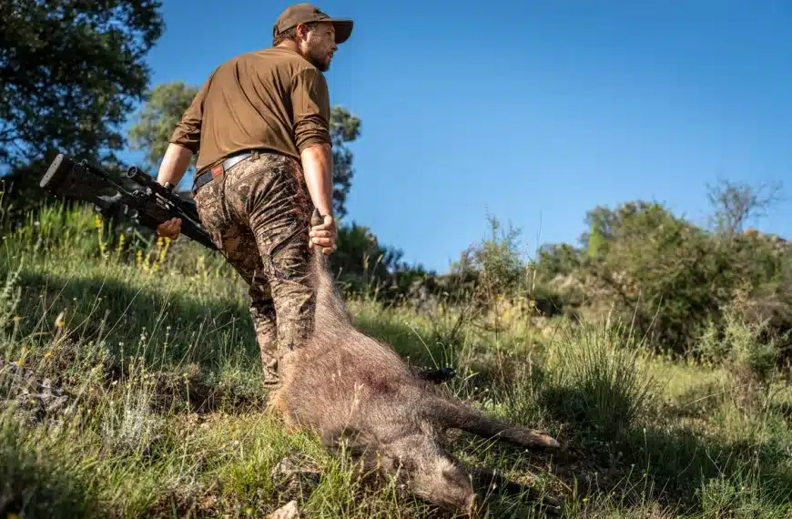 Un cazador con un jabalí.