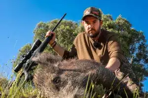 Un cazador con un jabalí.