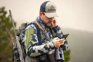 Un cazador consulta su móvil.