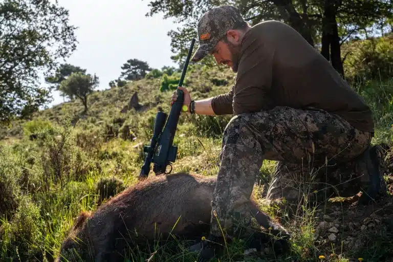 Cazador con jabalí recién abatido.