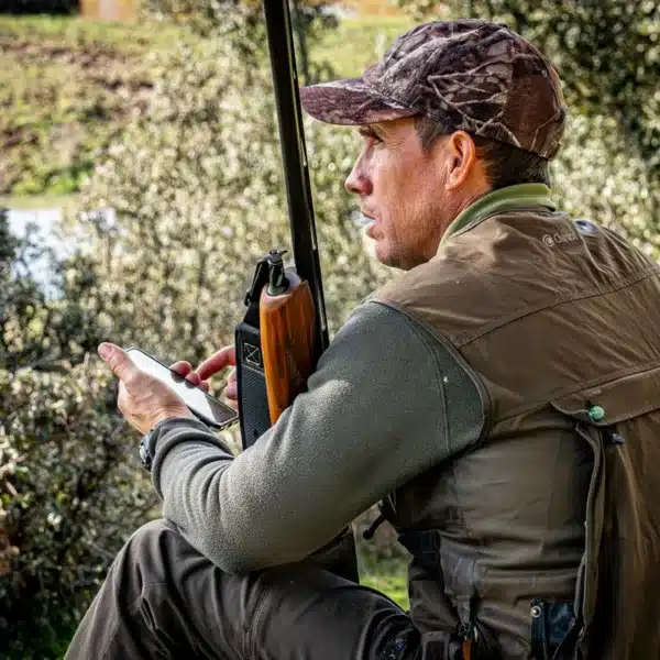 Un cazador con su smartphone de la mano.