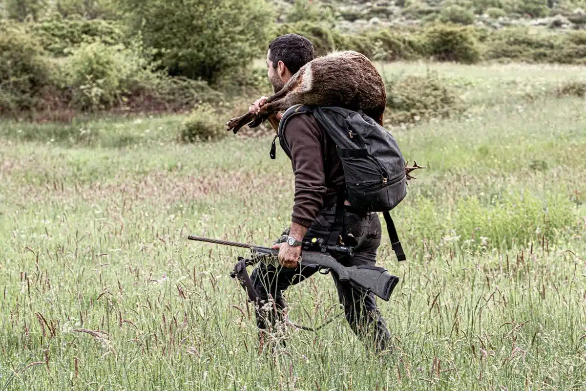 Un cazador con un corzo.