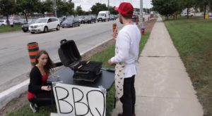 Un joven hace una barbacoa frente a una protesta de animalistas veganos